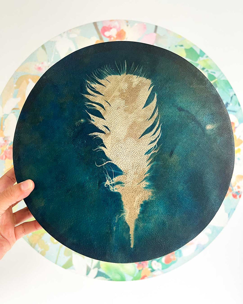 Handcrafted shamanic drum Dreamfeather by artist Ingrid Sanchez, featuring a blue cyanotype feather design.