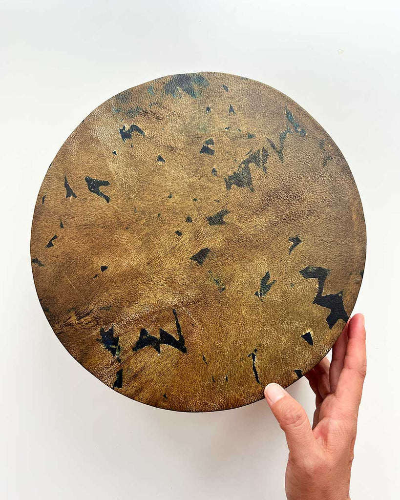 Earth Whisper shamanic drum with golden-painted willow hoop and intricate natural floral patterns on the hide.