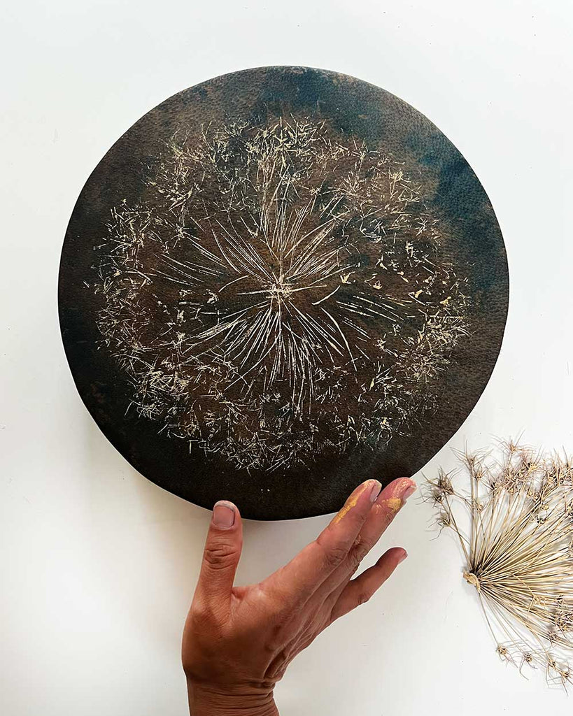 A Small Wish shamanic drum with hand-painted golden dandelion motif on dyed brown and blue goat hide.
