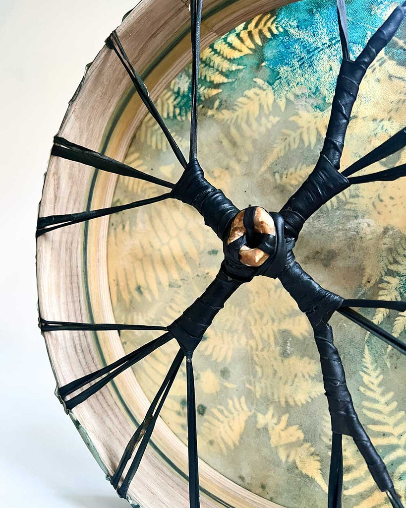 Close-up of the hag stone centerpiece symbolizing a belly button, shamanic drum by Ingrid Sanchez.