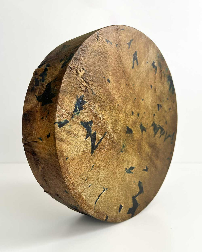 Earth Whisper drum displayed on a neutral surface, capturing its earthy tones, gold accents, and handmade craftsmanship.