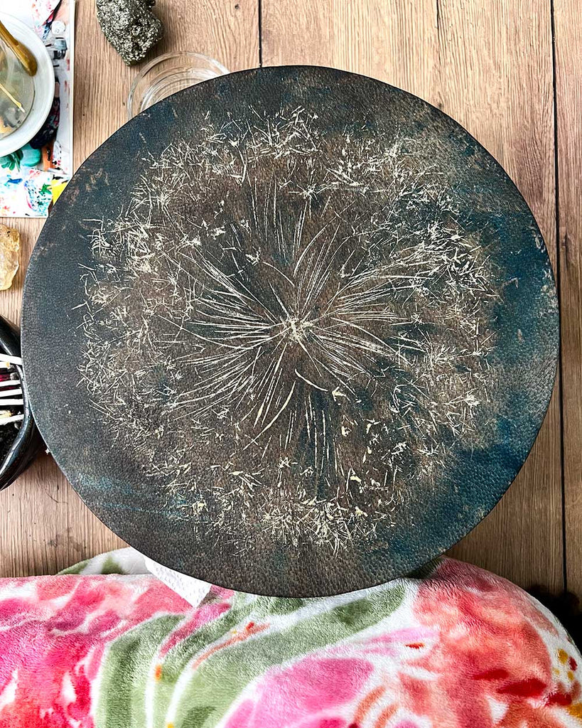 Close-up of golden dandelion details painted on the surface of the A Small Wish shamanic drum by Ingrid Sanchez.