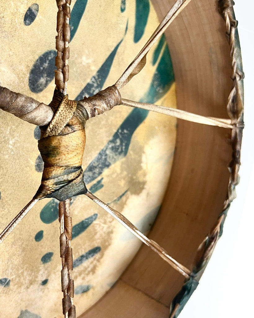 Close-up of large monstera leaf cyanotype on natural goat hide drum surface.