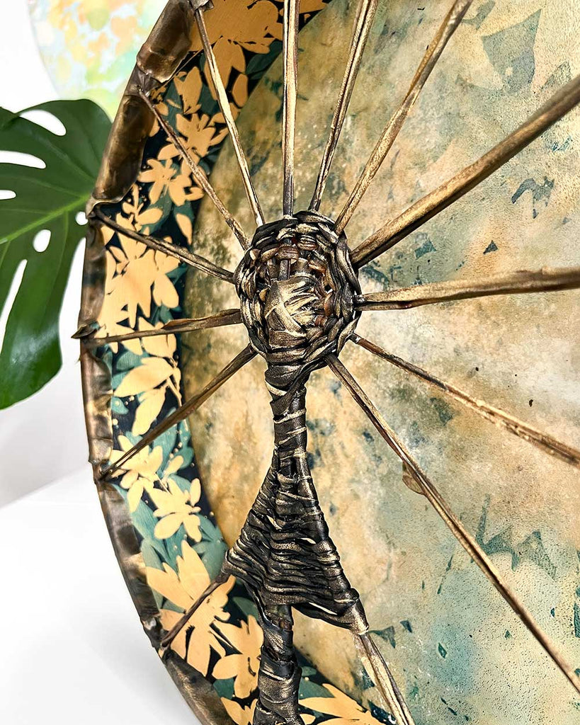 Side view of Gaia’s Heartbeat drum, 16-inch diameter, showing showing woven handle in the shape of a sun goddess figure.