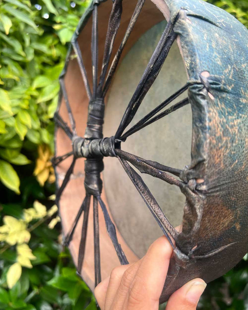 Back view of A Small Wish drum showing woven handle, ready for ceremonial use.