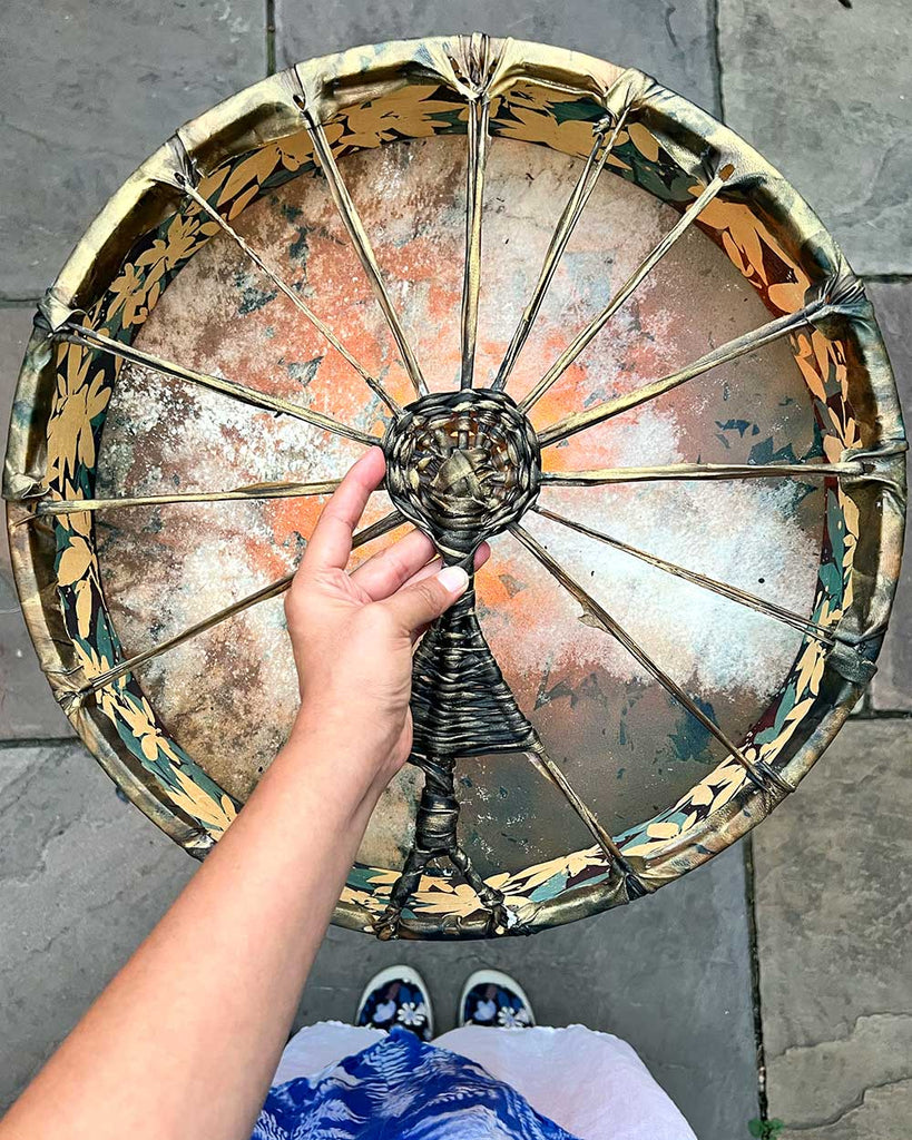 Back of Gaia’s Heartbeat drum showing woven handle in the shape of a sun goddess figure, highlighting ceremonial craftsmanship.
