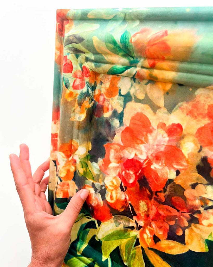 Side view of Crimson Garden silk painting on custom wooden frame, showing wrapped silk edges and luminous colors with fabric-like texture.