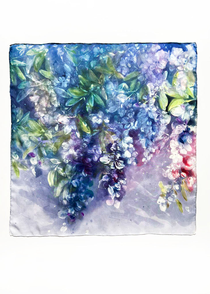 Delicate wisteria flowers transition beautifully from soft white to deep purple, set against a rich, deep purple background. Subtle green leaves peek through, adding a touch of freshness to the composition. Ingrid Sanchez, London 2025. Original Silk Painting.