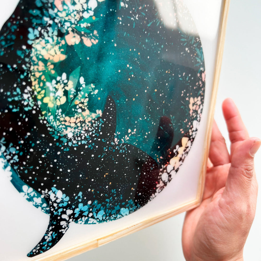 Framed artwork of a whale shark swimming beneath an indigo New Moon. CreativeIngrid resin-coated art prints.